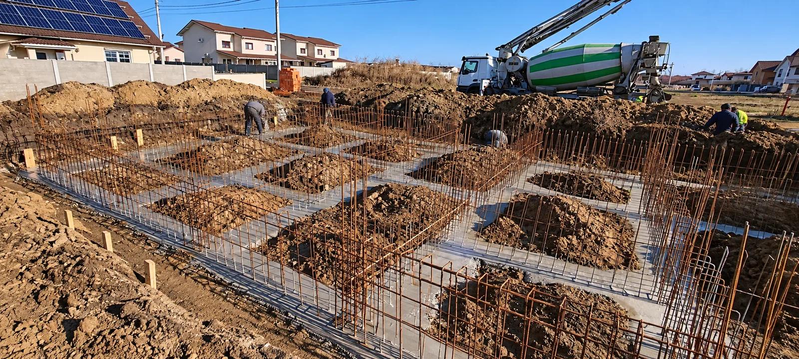Armătura fundației montată în săpătură, cu autobetoniera pregătită pentru turnare