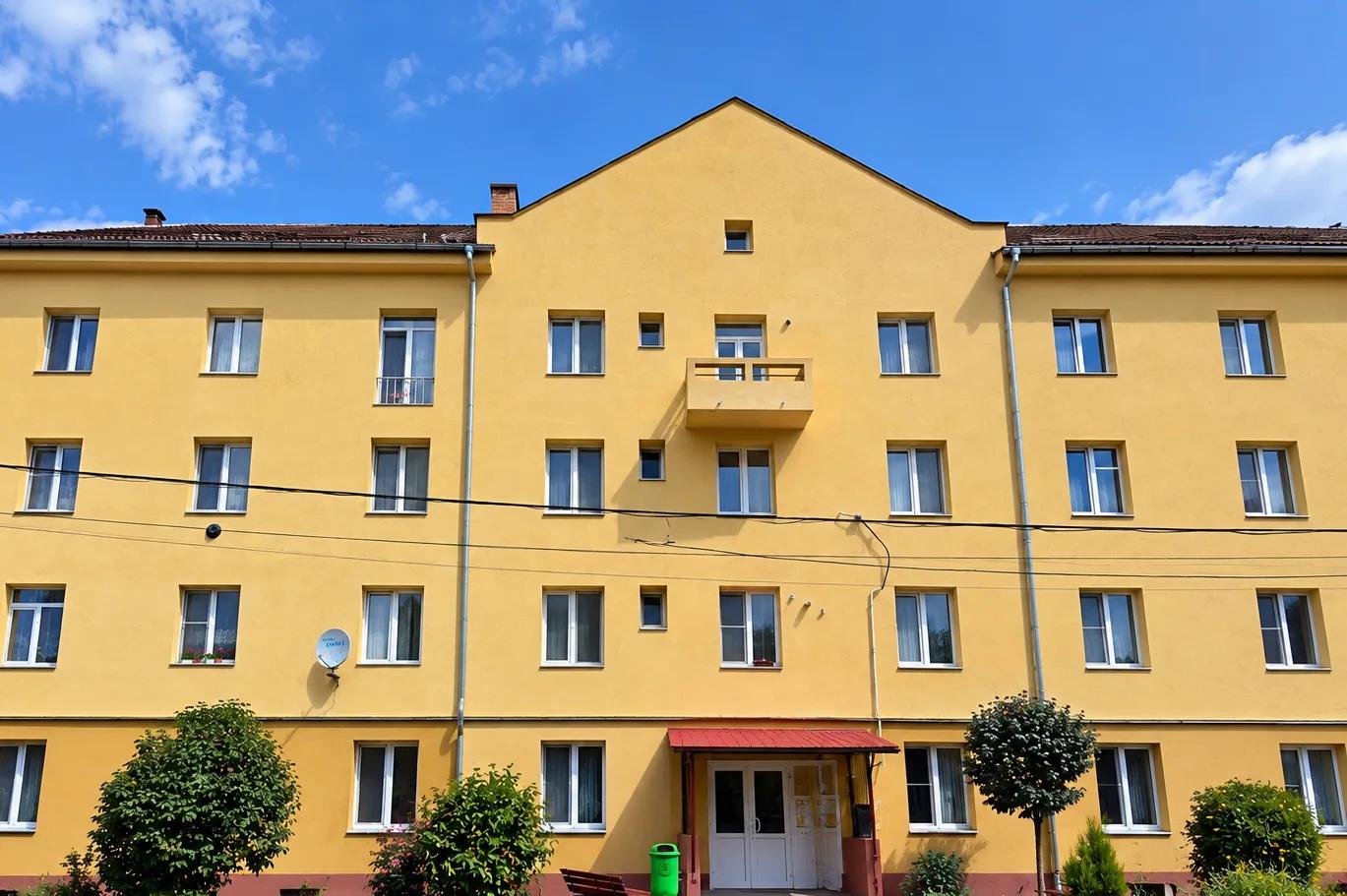 Fațada principală a blocului reabilitat, cu intrarea și balconul central