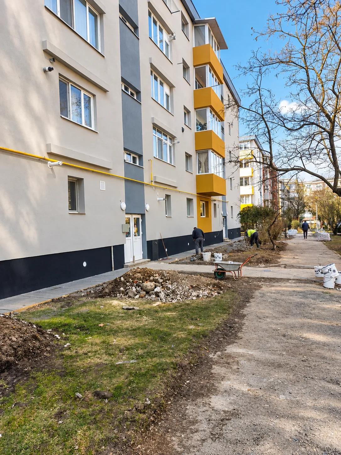 Lucrări de amenajare în fața blocului, după finalizarea fațadei