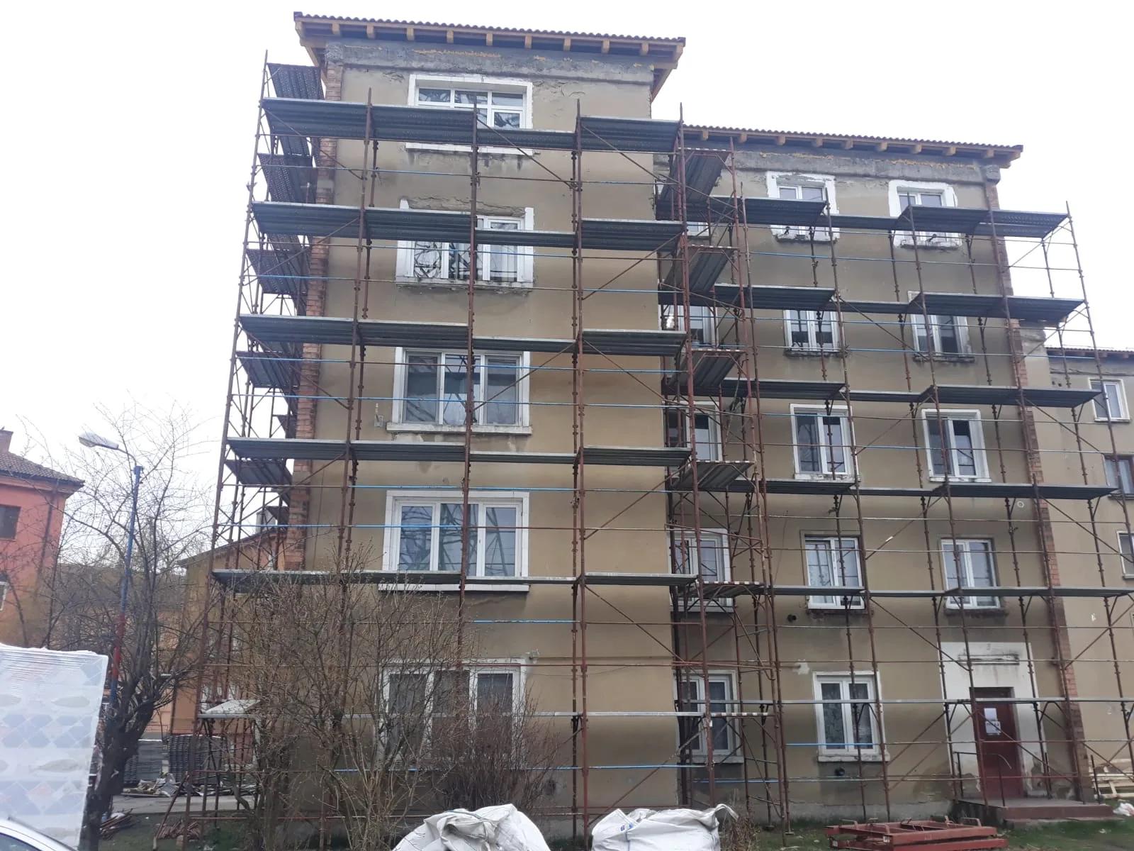 Fațada unui bloc pe schelă, cu termoizolația montată