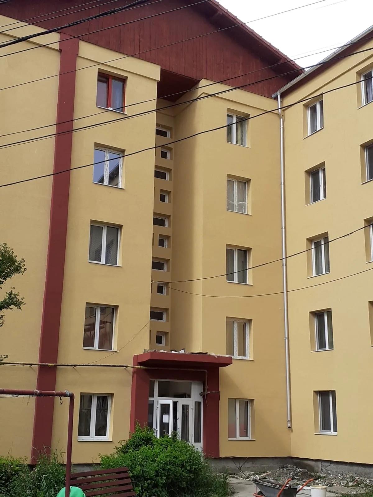 Intrarea unui bloc după reabilitare, cu fațada finisată