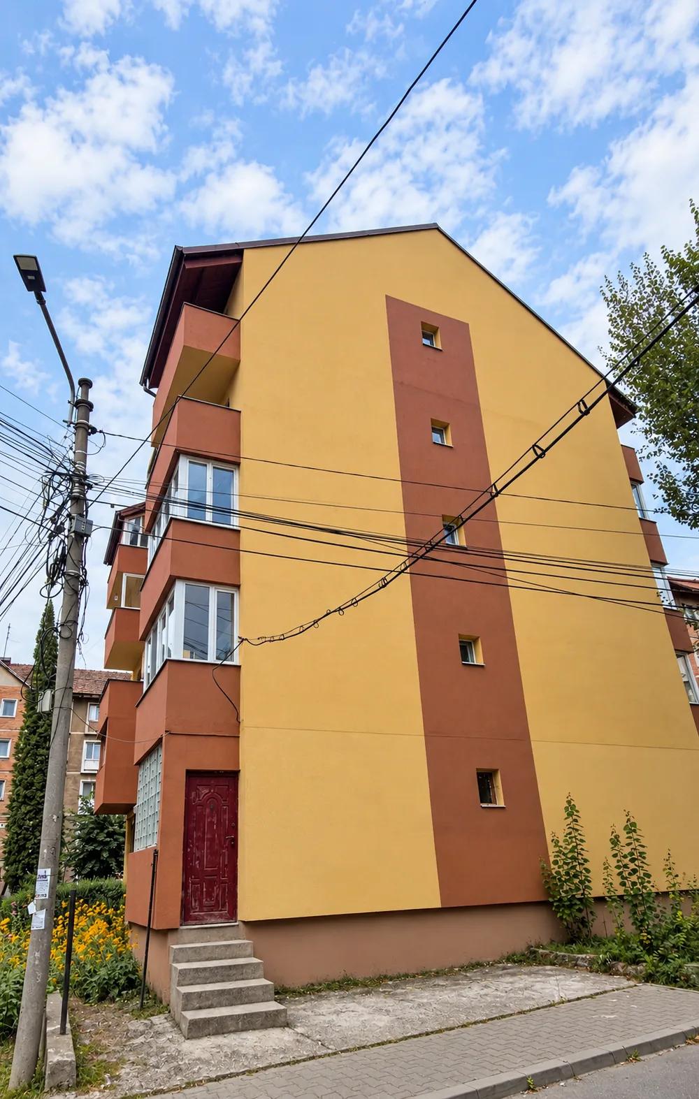 Fațada laterală a blocului termoizolat, cu o bandă verticală cărămizie